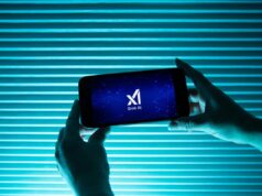 Engenheiros seniores, incluindo cofundadores, saem da xAI em meio a polêmica A person holds a telephone displaying the logo of Elon Musk s artificial intelligence grok in front of a background lit by a blue light.