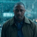 A man stands in a busy street with a concerned expression.