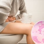 Uma mulher com dor de estômago no banheiro.