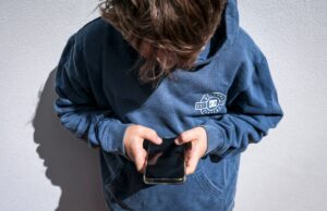 Estes são os países que estão se movendo para proibir as mídias sociais para crianças Shows a 14-year-old boy as he looks at social media on his mobile phone.