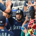O terceiro base do Seattle Mariners, Eugenio Suarez, cumprimenta os companheiros de equipe no banco de reservas depois de fazer um home run de duas corridas.