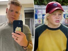 Ex-estrela infantil morreu repentinamente aos 33 anos Blake Garrett vestindo uma camiseta cinza e segurando um telefone na frente dele.