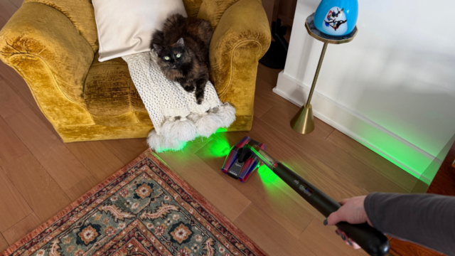 Dyson PencilVac no suporte de carregamento entre o aparador e a poltrona