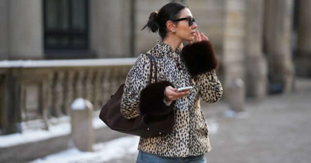 Aline Kaplan vestindo calças jeans azuis de perna larga Baum & Pferdgarten e outras histórias blusa cortada com padrão de flores brancas e salto laranja de verão e tons laranja preto Mango em 06 de junho de 2023 em Berlim, Alemanha.