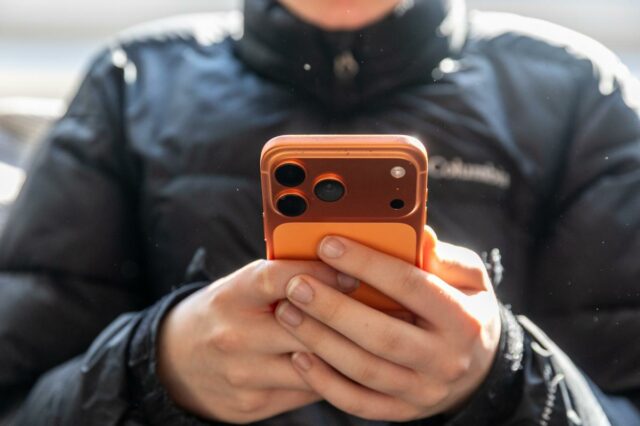 uma pessoa olhando para um telefone nas mãos
