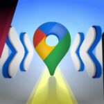 Mão colocando um alfinete grande do Google Maps em uma tela, cercado por ícones flutuantes que representam vários gestos de toque.