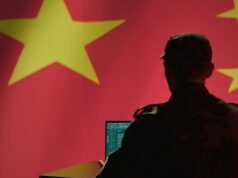 Hackers do Salt Typhoon da China invadiram empresas norueguesas A man sits in front of a computer and the Chinese flag.