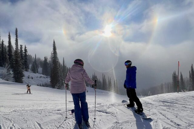 Happy Wanderer: ótimas escapadelas de esqui a poucos voos da Dois esquiadores na montanha Whitefish são banhados pela refração da luz solar através de cristais de gelo, um fenômeno chamado