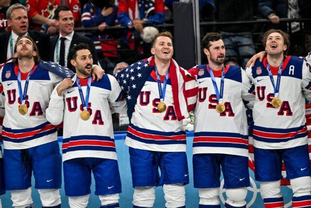 Hóquei masculino dos EUA atrai críticas após vitória olímpica sobre Team USA celebrate winning the gold medal during the Ice Hockey Men's Gold Medal Game match between Canada and USA on day sixteen of the Milano Cortina 2026 Winter Olympic games at Milano Santagiulia Ice Hockey Arena on February 22, 2026 in Milan, Italy.