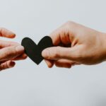 Meta, YouTube, TikTok e outros concordam em ser avaliados de acordo com os impactos na saúde mental | A imagem mostra um coração negro sendo passado de uma mão para outra