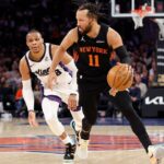 O guarda do New York Knicks, Jalen Brunson, entra na quadra enquanto o guarda do Sacramento Kings, Russell Westbrook, o persegue.