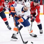 O ala esquerdo dos ilhéus, Jonathan Drouin, patina com o disco na frente do pivô do Capitals, Aliaksei Protas, durante o segundo período na segunda-feira, 2 de fevereiro de 2026, em Washington.