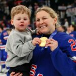 Medalhista de ouro Kendall Coyne, vestindo uma camisa azul com