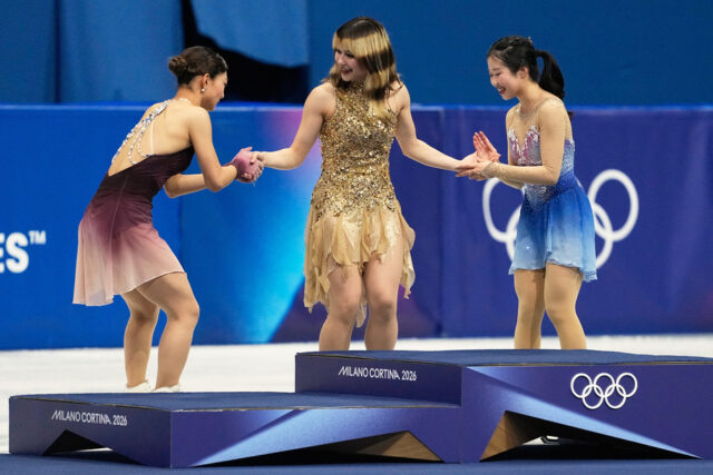 A partir da esquerda, Amber Glenn e a equipe de dança no gelo Madison Chock e Evan Bates comemoram a conquista da medalha de ouro após o evento da equipe de patinação artística nos Jogos Olímpicos de Inverno de 2026, em Milão, Itália, domingo, 8 de fevereiro de 2026. (AP Photo/Natacha Pisarenko)