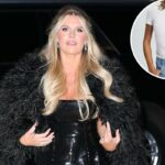 Uma mulher modela uma camiseta branca de manga curta e jeans de lavagem clara.