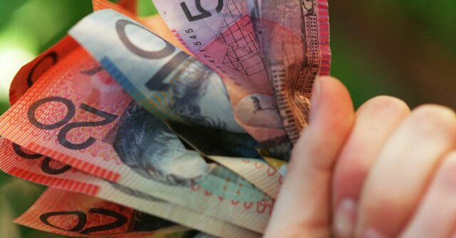 Alguém segurando um punhado de dinheiro australiano.