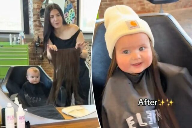 Uma mulher segurando extensões de cabelo em frente a um espelho, com um bebê com uma capa de barbeiro refletido no espelho.