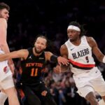 Jalen Brunson luta pela escolha de Donovan Clingan (à esquerda) enquanto defende Jerami Grant durante a vitória dos Knicks sobre os Trail Blazers em 30 de janeiro de 2026 no Madison Square Garden.