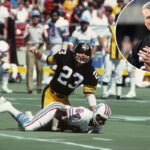 O zagueiro Mike Wagner nº 23 do Pittsburgh Steelers olha para cima depois de enfrentar o wide receiver Billy Johnson nº 84 do Houston Oilers durante um jogo no Three Rivers Stadium por volta de 1979 em Pittsburgh, Pensilvânia.