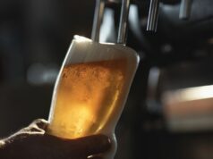 Milhares de freqüentadores de pubs correm o risco de serem enganados pelo tamanho das bebidas, diz relatório Cerveja fresca enchendo o copo diretamente da torneira. Com espuma extra derramando sobre o vidro.