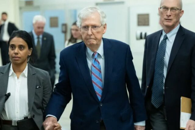 O senador americano Mitch McConnell, acompanhado por uma mulher e outro homem, caminha para as votações no Senado no 41º dia da paralisação do governo.