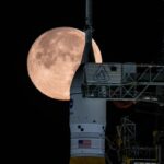 A lua cheia atrás do foguete SLS da NASA e da espaçonave Orion no Complexo 39B para um teste de abastecimento.