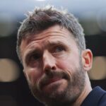 MIchael Carrick sai com o punho erguido, jogadores do United ao fundo