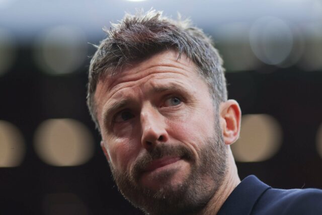 MIchael Carrick sai com o punho erguido, jogadores do United ao fundo