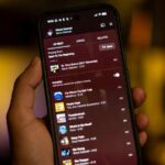 O logotipo do YouTube Music na parte superior de um smartphone em um fundo roxo e rosa