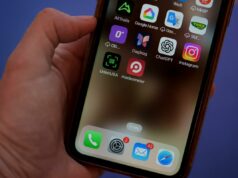 O boicote aos produtos dos EUA na Groenlândia aumenta à medida que o aplicativo registra um grande aumento nos downloads Close de uma mão segurando um smartphone exibindo aplicativos, incluindo