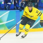 MILÃO, ITÁLIA - 11 DE FEVEREIRO: (NOTA DO EDITOR: A imagem foi capturada usando uma câmera remota posicionada acima do campo de jogo.) Matt Bradley nº 13 da equipe da Itália e Alexander Wennberg nº 10 da equipe da Suécia se enfrentam no primeiro período durante a partida preliminar masculina do Grupo B entre Suécia e Itália no quinto dia dos Jogos Olímpicos de Inverno de Milano Cortina 2026 na Arena de Hóquei no Gelo Milano Santagiulia em 11 de fevereiro de 2026 em Milão, Itália. (Foto de Bruce Bennett/Getty Images)