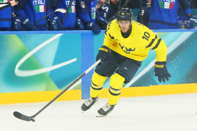MILÃO, ITÁLIA - 11 DE FEVEREIRO: (NOTA DO EDITOR: A imagem foi capturada usando uma câmera remota posicionada acima do campo de jogo.) Matt Bradley nº 13 da equipe da Itália e Alexander Wennberg nº 10 da equipe da Suécia se enfrentam no primeiro período durante a partida preliminar masculina do Grupo B entre Suécia e Itália no quinto dia dos Jogos Olímpicos de Inverno de Milano Cortina 2026 na Arena de Hóquei no Gelo Milano Santagiulia em 11 de fevereiro de 2026 em Milão, Itália. (Foto de Bruce Bennett/Getty Images)