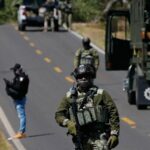 Um soldado ultrapassa uma barreira perto de Tapalca, um dia depois de violentas represálias por parte de membros do cartel.
