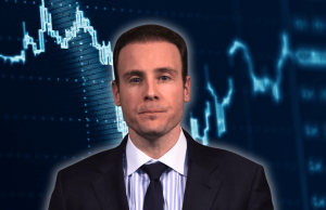 O curioso caso de Michael Selig e suas previsões sobre os mercados O curioso caso de Michael Selig e as suas previsões sobre os mercados. O presidente da CFTC, Mike Selig, de terno escuro e gravata, enfrenta a câmera contra um fundo azul com gráficos financeiros estilizados e gráficos de dados de mercado.