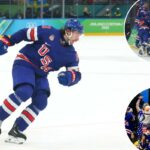 O jogador de hóquei no gelo Quinn Hughes em um uniforme azul do time dos EUA, patinando no gelo.