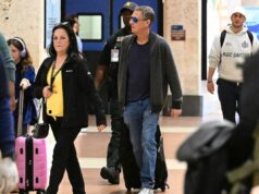 O marido de Savannah Guthrie, Michael Feldman, visto em público pela primeira vez desde o desaparecimento da sogra Nancy Michael Feldman, marido de Savannah Guthrie, caminhando por um aeroporto da Flórida com uma mala rosa, seguido por uma criança com fones de ouvido lilás e um policial.