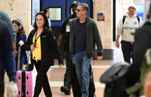 O marido de Savannah Guthrie, Michael Feldman, visto em público pela primeira vez desde o desaparecimento da sogra Nancy Michael Feldman, marido de Savannah Guthrie, caminhando por um aeroporto da Flórida com uma mala rosa, seguido por uma criança com fones de ouvido lilás e um policial.