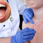 Close extremo da boca aberta de uma jovem com dentes brancos perfeitos e uma língua rosada.