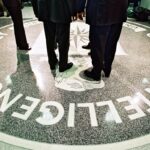 386984 06: President George W. Bush, Central Intelligence Agency Director George Tenet and others stand on the seal of the Agency March 20, 2001 at the CIA Headquarters in Langley, Virginia. Bush toured the facility and met some of the Agency''s employees. (Pool Photo by David Burnett/Newsmakers)