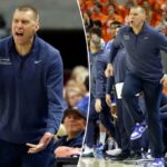 O técnico do Kentucky, Mark Pope, reagindo a uma ligação durante um jogo de basquete.