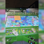 Oito presos porque um cassino ilegal foi fechado pela polícia na Pensilvânia. Close de uma mesa de jogo de cassino ilegal apreendida durante uma operação policial, mostrando uma superfície de jogo colorida com gráficos com tema subaquático, dinheiro espalhado, fichas estilo pôquer e pequenas estatuetas, com partes da máquina abertas e fiação exposta, indicando que ela foi desligada e confiscada.