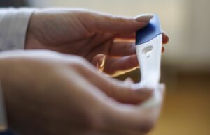 ‘Os australianos não estão escolhendo carreiras em vez de filhos, eles estão escolhendo a sobrevivência financeira’ Mulher esperando o resultado do teste de gravidez