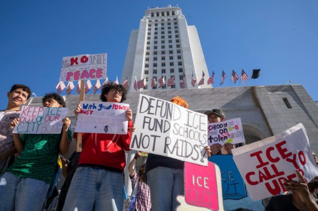 Os educadores precisam parar de radicalizar as crianças Estudantes protestam contra o ICE em frente à Prefeitura, segurando cartazes que dizem