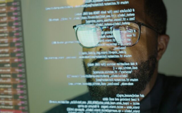 Man studying a see-through display depicting Python computer coding.