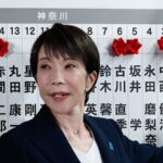 Sanae Takaichi coloca uma rosa vermelha no nome de um de seus candidatos vencedores na sede do partido LDP.