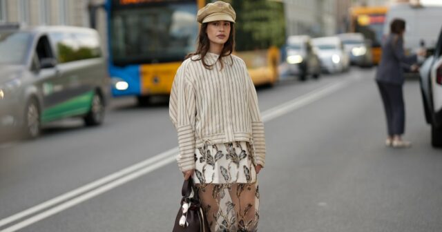 PARIS, FRANÇA - 25 DE JANEIRO: Constance Jablonski usa longos cabelos loiros ondulados com uma parte central, brincos de argola de metal, uma bolsa clutch de couro preta, uma jaqueta preta grande com listras jacquard com logotipo PATOU tonal, gola de couro texturizada e detalhes de fivela de metal em camadas sobre um top preto, uma minissaia combinando, bota skinny de couro preto brilhante, fora de Patou, durante a Paris Fashion Week - Moda masculina outono / inverno 2026-2027, em 25 de janeiro de 2026 em Paris, França (Foto de Edward Berthelot/Getty Images)