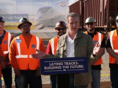 Pise no freio na loucura ferroviária de Newsom O governador da Califórnia, Gavin Newsom, aperta a mão de um trabalhador do Iron Workers Local 155 enquanto Ian Choudri, CEO da Autoridade Ferroviária de Alta Velocidade da Califórnia, observa.