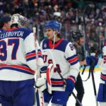 Os jogadores de hóquei no gelo da equipe dos EUA Connor Hellebuyck, Jack Hughes e JT Miller comemoram sua vitória na semifinal.