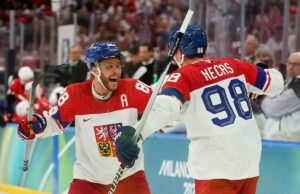 Previsão Dinamarca x Tcheca: probabilidades, escolhas e melhor aposta no hóquei olímpico masculino Os jogadores dinamarqueses de hóquei no gelo Lars Eller, Oliver Bjorkstrand e Nikolaj Ehlers em uniformes vermelhos e brancos durante uma partida nos Jogos Olímpicos de Inverno de Milão Cortina 2026.