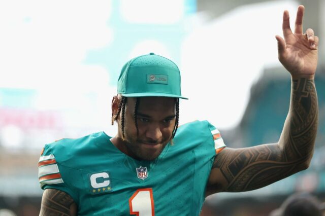 Tua Tagovailoa é demitida por Payton Wilson e Alex Highsmith durante um jogo de futebol americano da NFL.